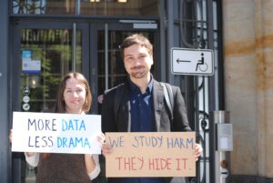 A photo of the CITR team outside the court holding signs including "we study data, they hide it" and "More data less drama"
