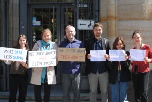 A photo of the CITR team outside the court holding signs including "we study data, they hide it"